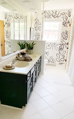 a white bathroom with black and white wallpaper on the walls, sink and mirror