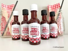 four bottles of bbq sauce sitting on a table