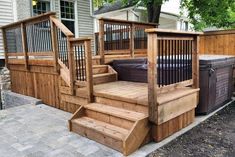 a wooden deck with hot tub and stairs