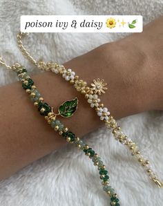 a woman's arm with two bracelets that have flowers and leaves on them