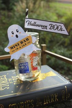 there is a halloween decoration in a jar on top of a book with a sign