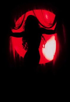 the silhouette of a woman in front of a red light with her arms spread out