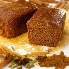 two pieces of bread sitting on top of a wooden cutting board next to cinnamon sticks