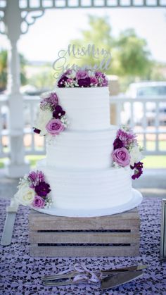 a wedding cake sitting on top of a wooden box