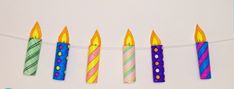 five birthday candles are lined up on a string