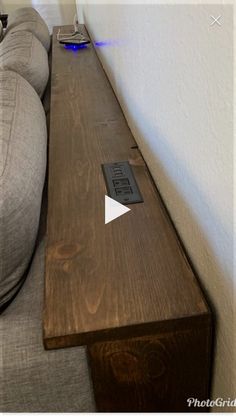 a couch sitting next to a wall with a remote control on it's side