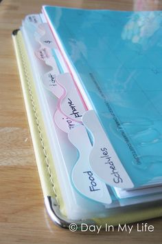 a close up of a binder on a wooden table with paper attached to it