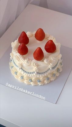 a cake with white frosting and strawberries on top