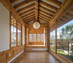 an empty room with lots of windows and wood paneling on the walls, along with bikes parked in the background