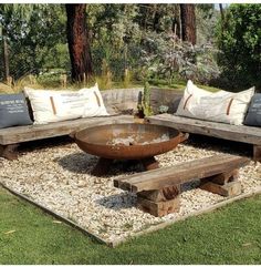 an outdoor seating area with wooden benches and pillows