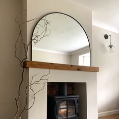 a fireplace with a mirror above it and a wood burning stove in the corner next to it