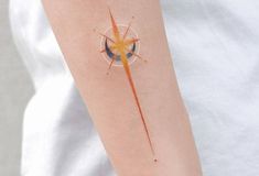 a person with a tattoo on their arm that has an orange and blue star in it