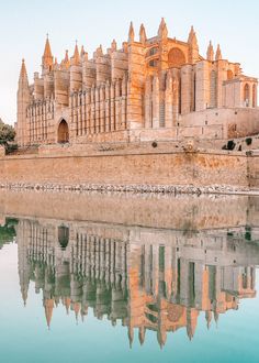 an old castle is reflected in the water