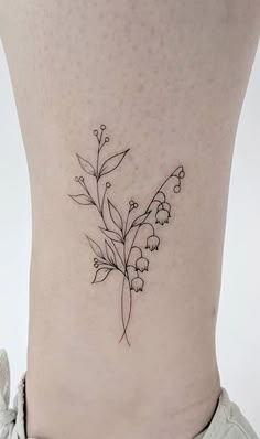 a small flower tattoo on the side of a woman's lower back ribcage