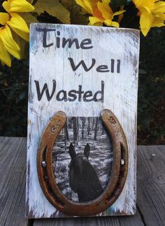 a wooden sign that says time well wasted with an image of a horse on it