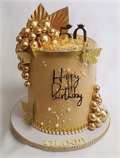 a birthday cake with gold decorations on it