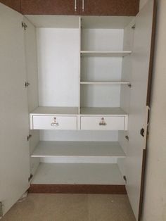 an empty closet with white drawers and brown trim on the bottom shelf is seen in this image