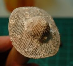 a person is holding a small mesh object