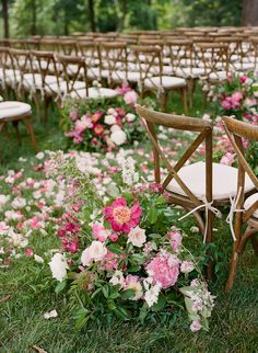 an outdoor ceremony with chairs and flowers in the grass