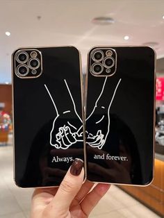 someone holding up two cell phones with the same image on them in front of a store