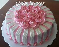 a pink and white decorated cake on top of a table