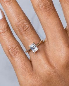 a woman's hand with a ring on it and a diamond in the middle