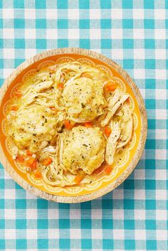 a bowl filled with meatballs and noodles on top of a blue checkered table cloth