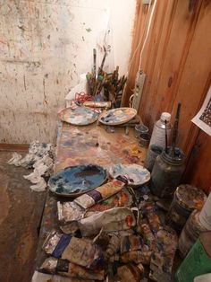 the room is full of dirty plates and paintbrushes