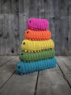 a stack of crocheted hats sitting on top of a wooden table