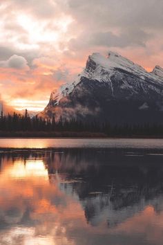 the mountains are reflected in the water as the sun goes down on it's reflection