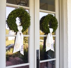 two wreaths are hanging on the front door