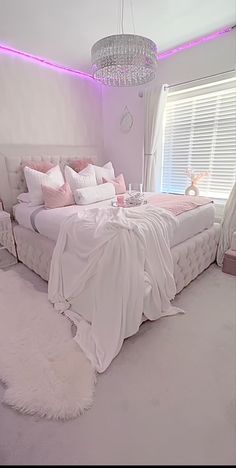 a white bedroom with pink accents and lights on the ceiling is pictured in this image