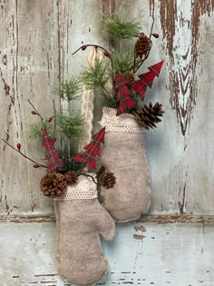 two mittens decorated with pine cones and evergreen needles