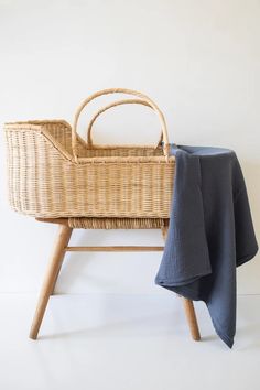 a wicker baby crib with a blue blanket on it