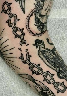 a man's foot with tattoos on it and chains around the ankles, including a skull