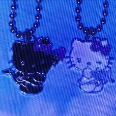 two black and white teddy bears are hanging from chains on a television screen with blue background