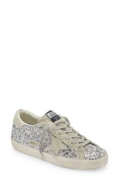 Shimmering glitter brings a dazzling finish to a skate-inspired sneaker, hand-distressed and scuffed for an instant worn-in look. Lace-up style Synthetic, textile and leather upper/leather and textile lining/rubber sole Made in Italy Designer Shoes Metallic Low-top Sneakers With Glitter Accents, Sparkling Low-top Sneakers For Streetwear, Sparkling Low-top Sporty Sneakers, Sporty Sparkling Low-top Sneakers, Sporty Low-top Sparkling Sneakers, Golden Goose Deluxe Brand, Super Star, Golden Goose, Perm