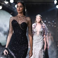 two models walk down the runway in evening gowns and headpieces that are embellished with sequins