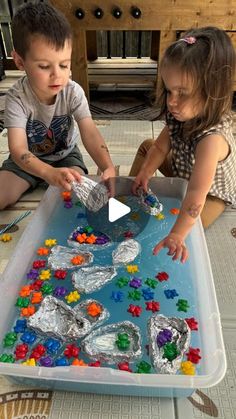 two children are playing with an ice tray made out of candy and gummy bears