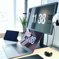 an open laptop computer sitting on top of a wooden desk next to a monitor and mouse