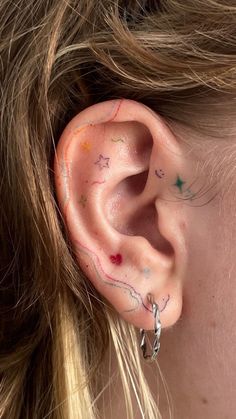 a close up of a person's ear with stars painted on the inside of it