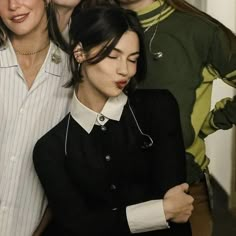 a group of women standing next to each other in front of a mirror with their eyes closed