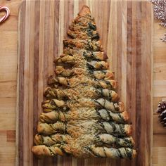 a christmas tree shaped pastry sitting on top of a wooden cutting board