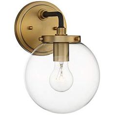 an antique brass wall light with clear glass globe shade