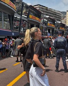 a group of people standing in the middle of a street with police officers behind them