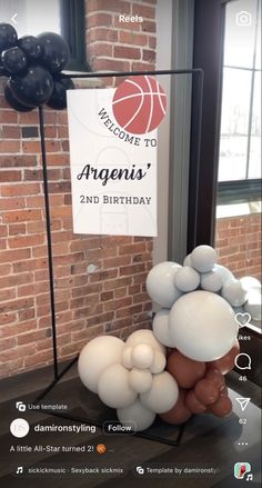 balloons are arranged in the shape of a man's head on a table next to a sign that says welcome to arenais 2nd birthday