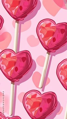 several lollipops on a pink background with hearts