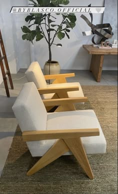 a white chair sitting on top of a rug next to a plant in a vase