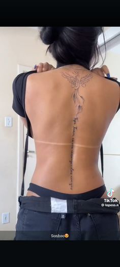 the back of a woman's body with tattoos on her upper and lower back