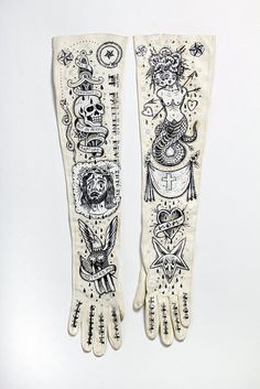 two white gloves with designs on them